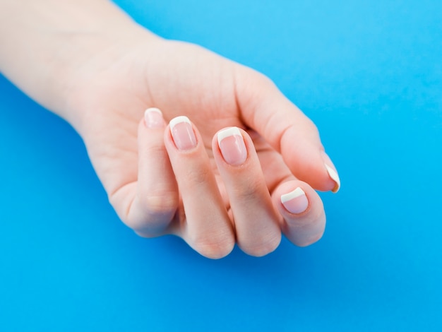 Manicured hand on blue background