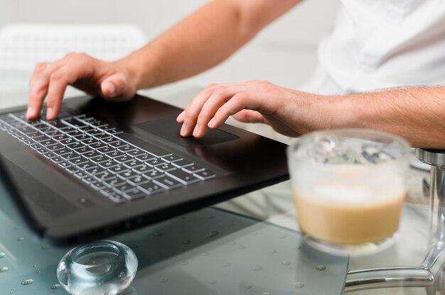 Mans hands pressing the keys of the laptop