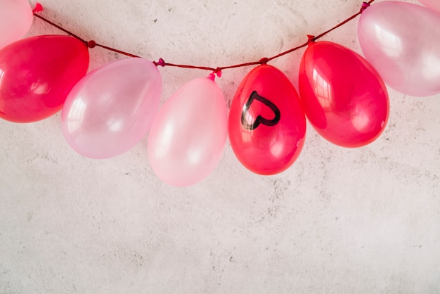 Many balloons with painted heart hanging on twist