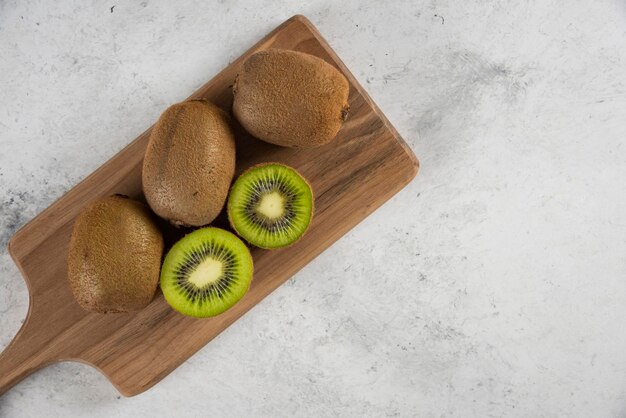 Many of delicious kiwi fruits on wooden board. 