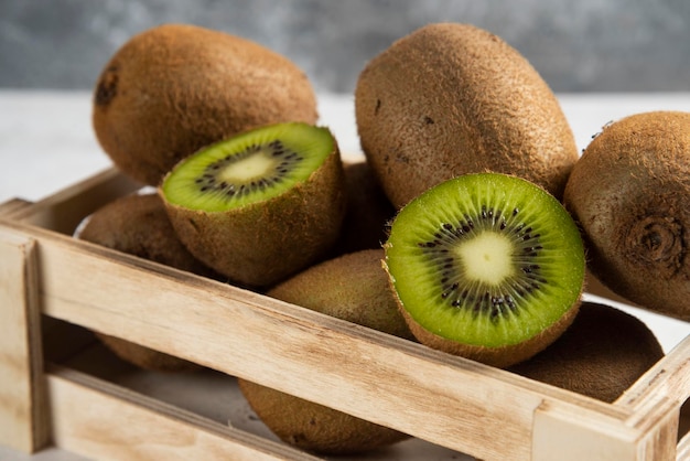 Free photo many of fresh kiwi fruits on wooden basket.