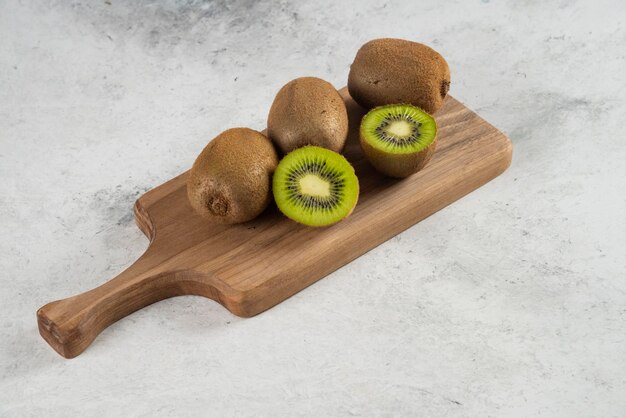 Many of fresh kiwi fruits on wooden board. 