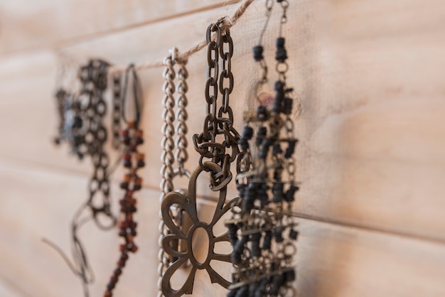 Free Photo many metallic bracelets hanging on string against wooden wall