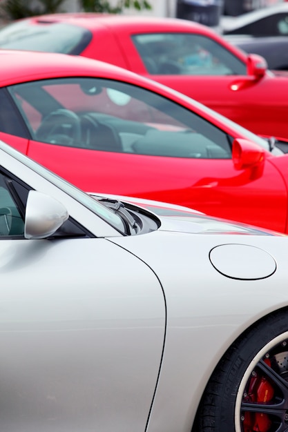 Many sports cars parked in a row, vertical view