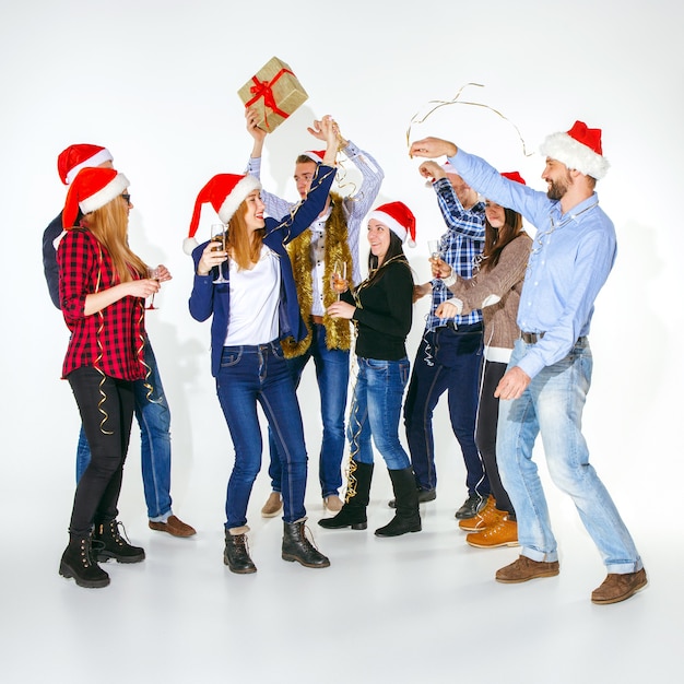 Free photo many young women and men drinking at christmas party on white studio