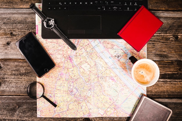 Free photo map, coffee, electronic equipment and accessories on wooden table