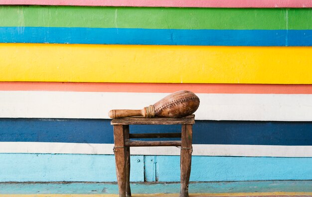 Maraca alongside vibrant wall in stripes with copy-space