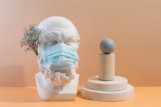 Free Photo marble sculpture of historical figure with medical mask and flowers