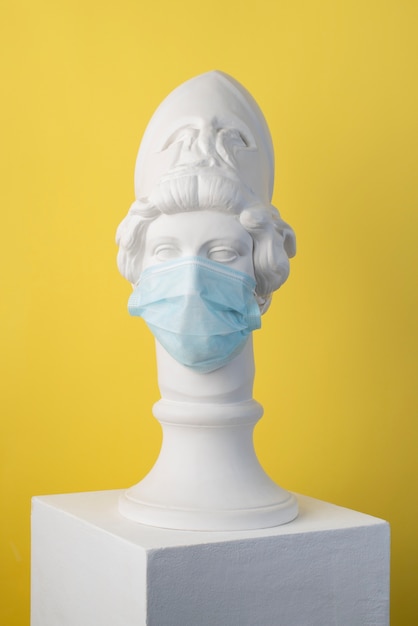 Free photo marble sculpture of historical figure with medical mask