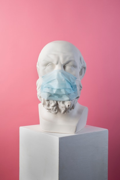 Marble sculpture of historical figure with medical mask