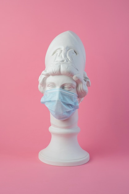 Marble sculpture of historical figure with medical mask