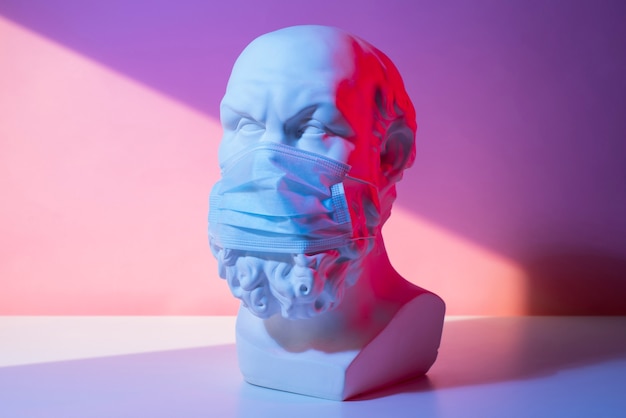 Free photo marble sculpture of historical figure with medical mask