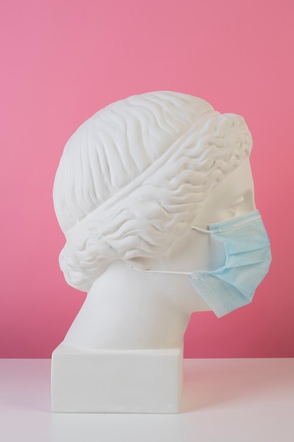 Free photo marble sculpture of historical figure with medical mask