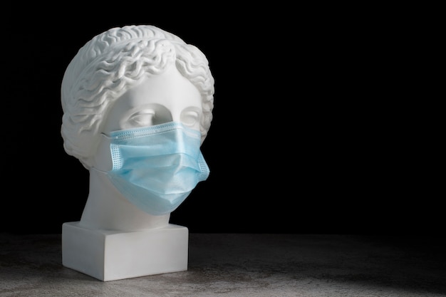 Free Photo marble sculpture of historical figure with medical mask