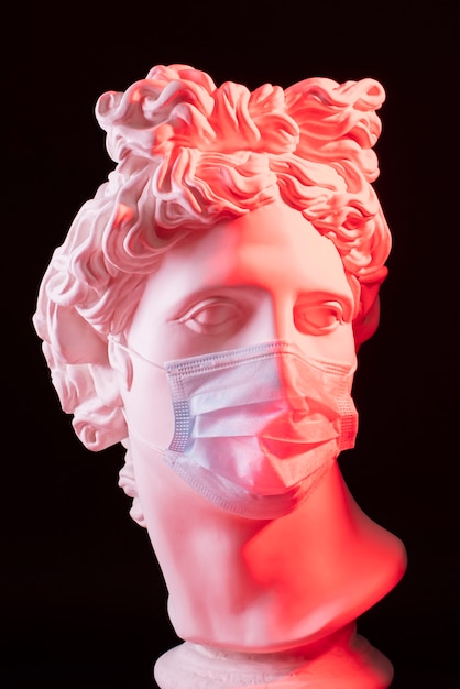 Marble sculpture of historical figure with medical mask