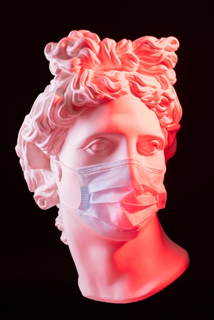 Marble sculpture of historical figure with medical mask