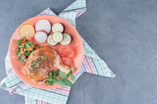 Marinated chicken and sliced vegetables on orange plate.