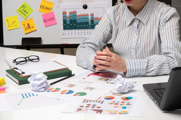 Marketing business lady in striped shirt in office with glasses on desk crossing hands with cup