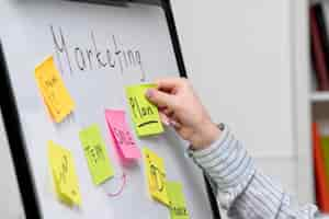 Free photo marketing young cute business lady in striped shirt in office creating new marketing plan