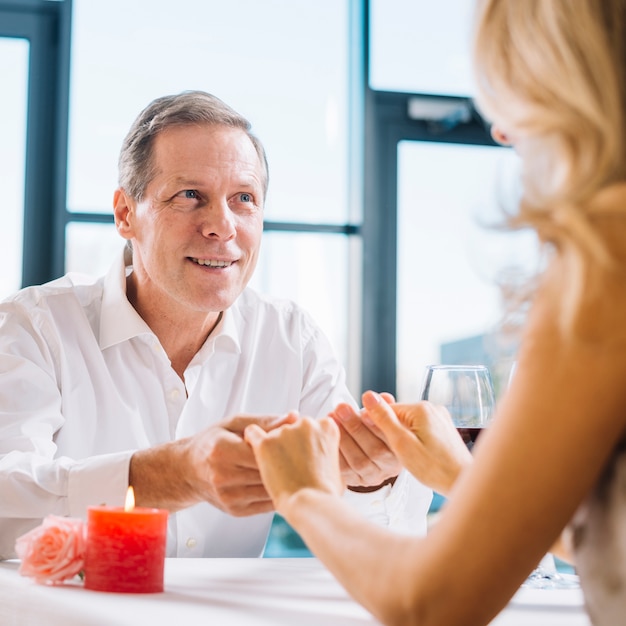 Married couple holding hands during romantic dinner