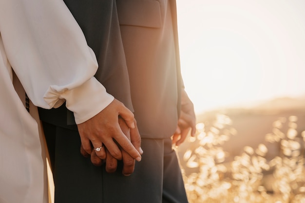 Free photo married couple holding hands side view