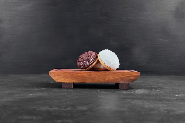 Free Photo marshmallow cookies on a wooden platter on black