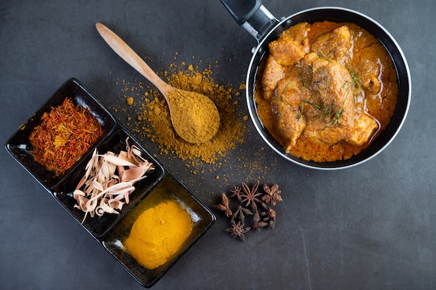 Free photo massaman curry in a frying pan with spices on the cement floor