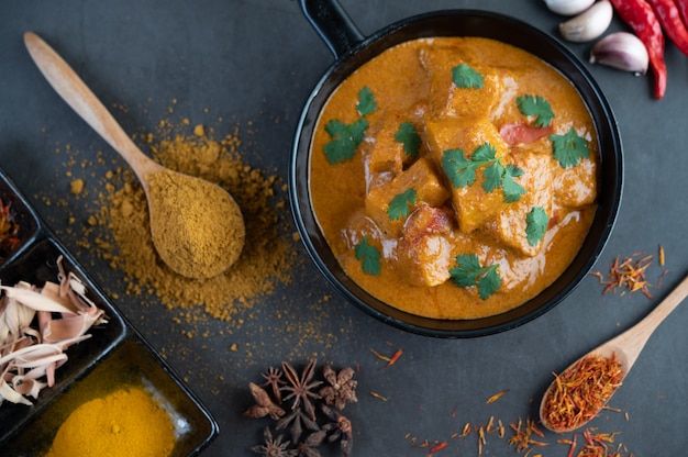 Free photo massaman curry in a frying pan with spices on the cement floor