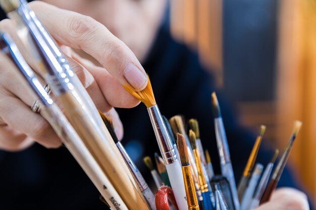 Master choosing painting brush from the stock