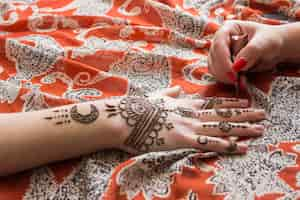 Free photo master tattooing mehndi paint on woman hand