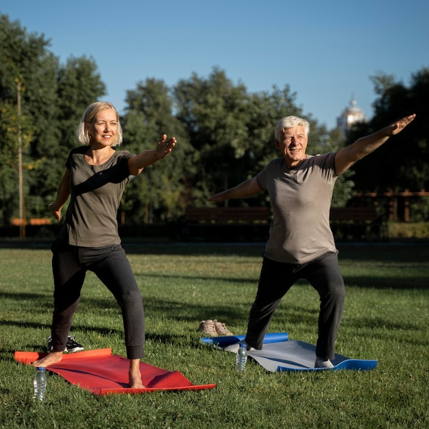 Mature couple doing yoga outside