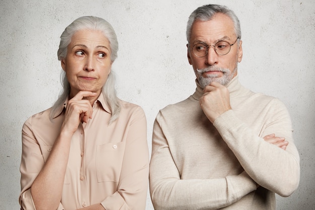 Mature couple posing against concrete wall