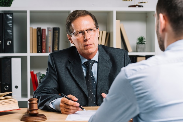 Free photo mature lawyer with clients in a meeting