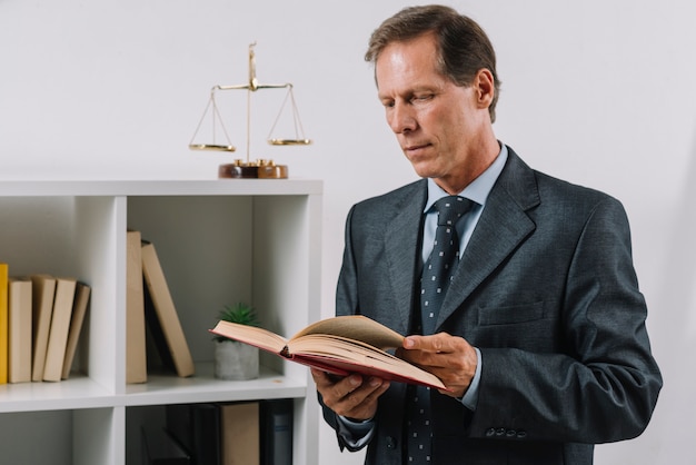 Free photo mature male reading legal book in the courtroom