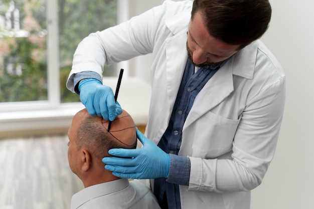 Free photo mature man going through a follicular unit extraction process