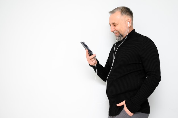 Mature man looking on his phone with copy space