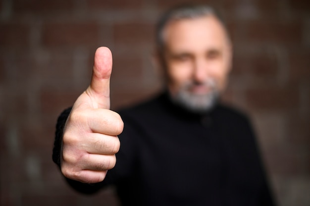 Free photo mature man making the thumbs up sign