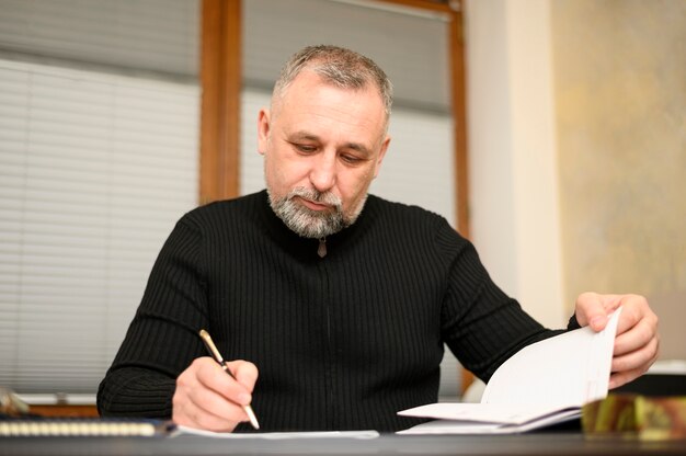 Mature man writing on a notebook