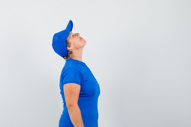 Free photo mature woman in blue t-shirt bending head back and looking peaceful .