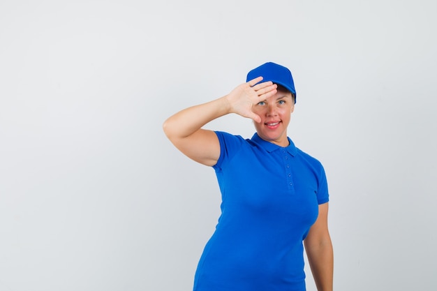 Mature woman in blue t-shirt showing palm to say goodbye