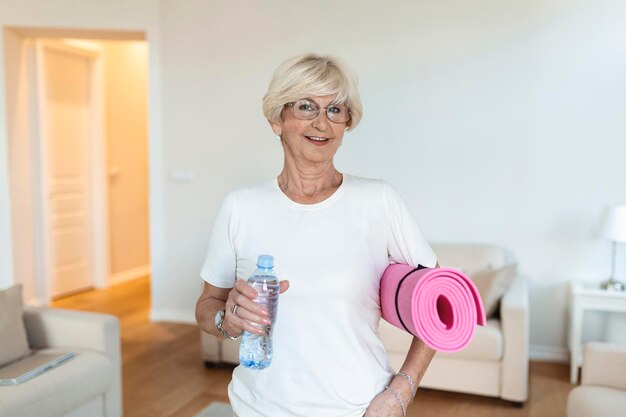 Mature Woman getting ready for a workout Elderly woman ready for working out Refreshment after training Sporty old woman drinking water