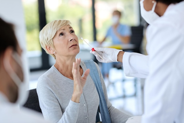 Free photo mature woman getting tested for coronavirus at medical clinic