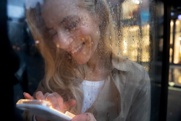 Mature woman texting on the phone while it rains