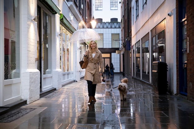 Free Photo mature woman walking her dog while it rains