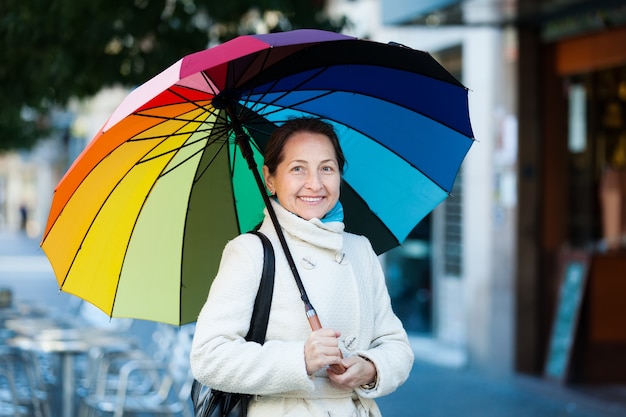 mature woman with umbrella in autumn