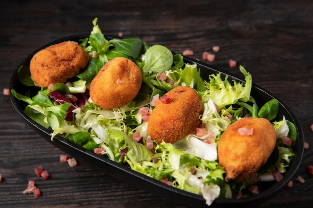 Free Photo meal containing croquettes with bacon and salad