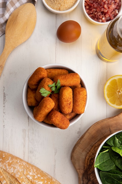 Free photo meal containing croquettes with bacon and spinach