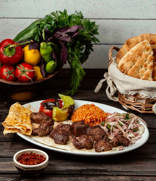 Meat bulgur and onion with sumac on a wooden table