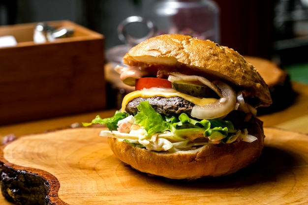 Meat burger tomato onion coleslaw cheese cucumber side view