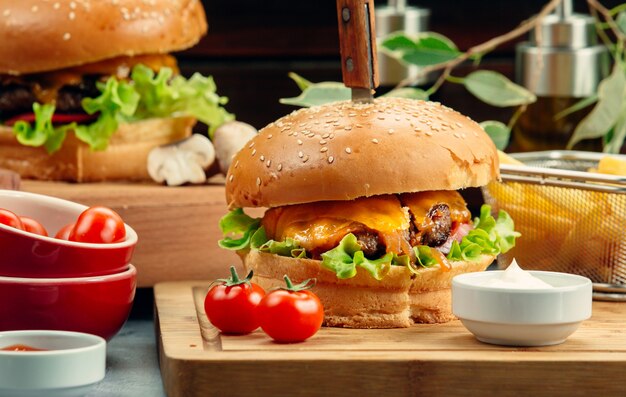 meat burger with melted cheddar tomato and lettuce